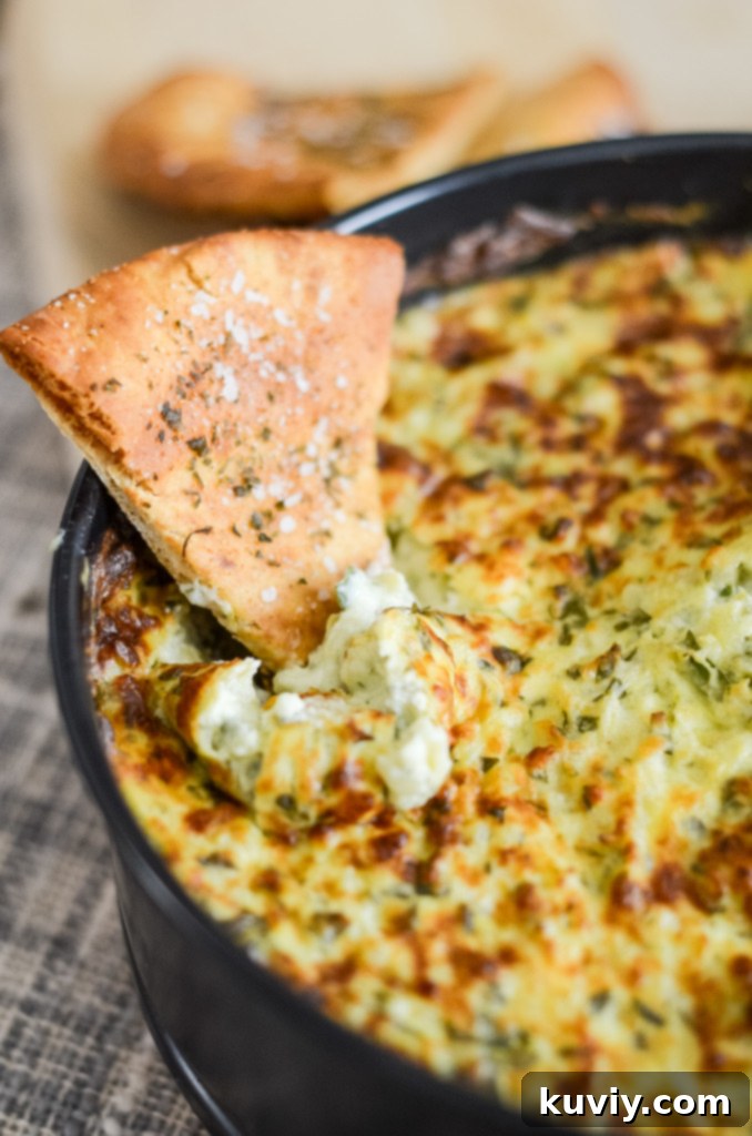 Delicious and creamy air fryer spinach dip in a white serving dish, garnished with fresh herbs, ready to be enjoyed with dippers.
