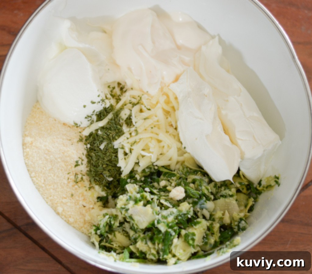 All ingredients for air fryer spinach dip mixed thoroughly in a bowl, showing a creamy, chunky texture before cooking.