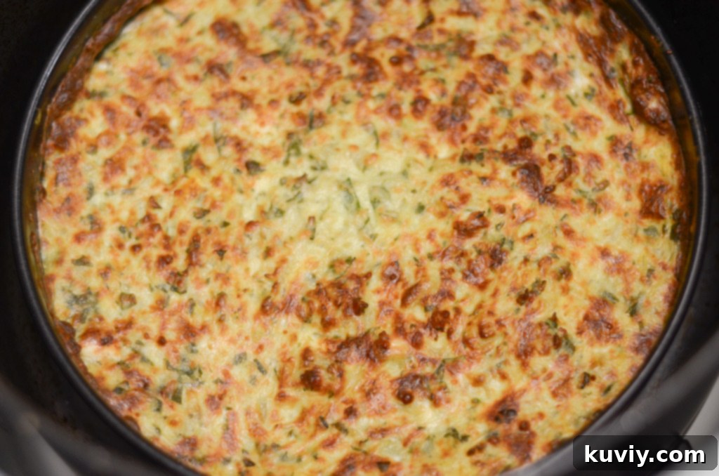 Air fryer basket with a pan of spinach dip baking inside, illustrating the correct placement for optimal air frying.