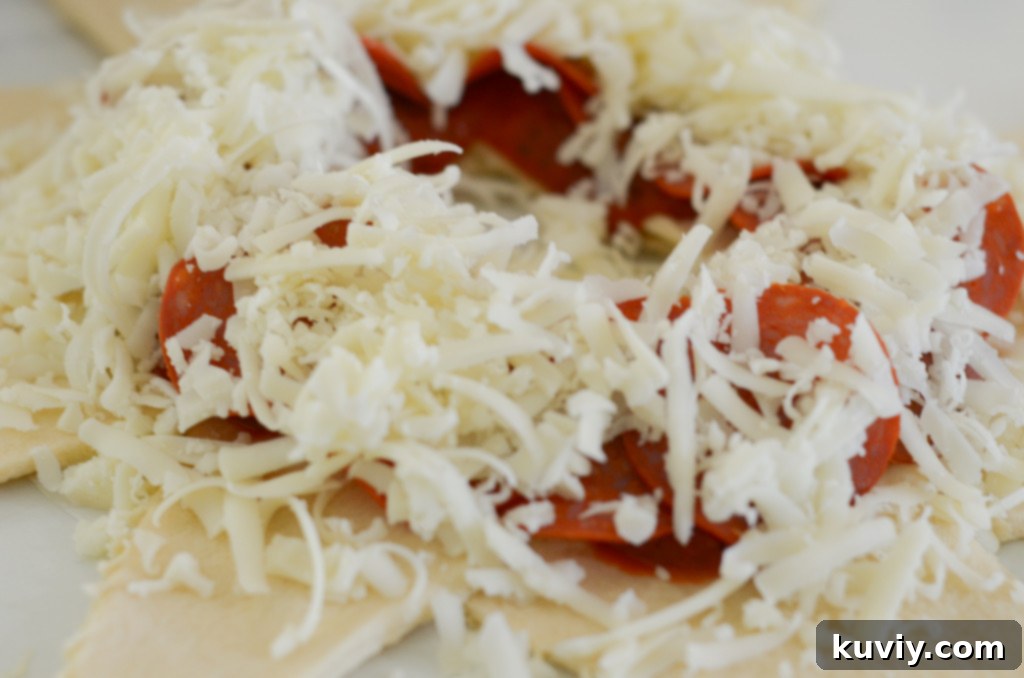 Assembling air fryer pizza ring with sauce, pepperoni, and cheese on crescent rolls