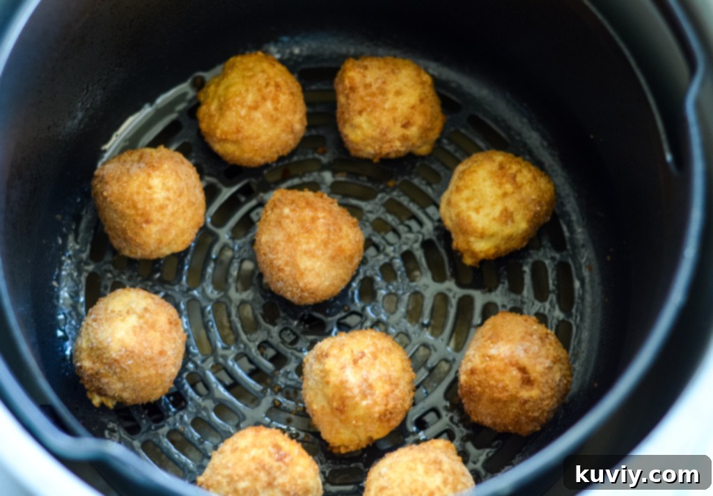 Crispy Air Fryer Frozen Mac and Cheese Bites 4 Spraying air fryer basket with grapeseed oil for mac and cheese bites
