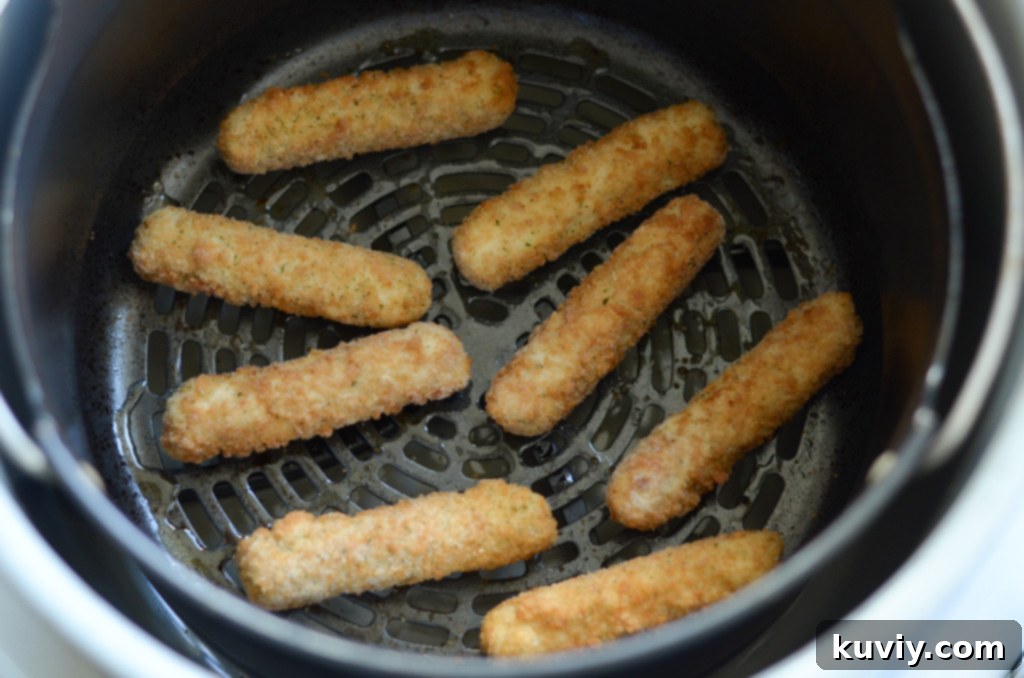 Frozen Mozzarella Sticks arranged in air fryer basket