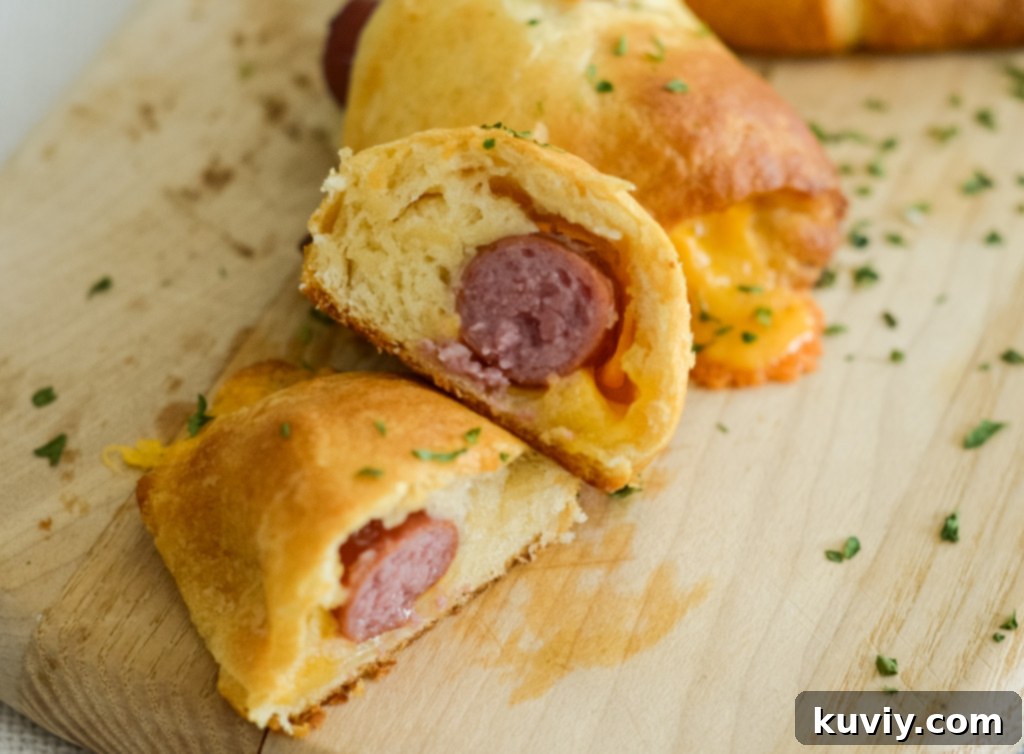 This image shows a cut open air fryer pigs in a blanket with cheese.
