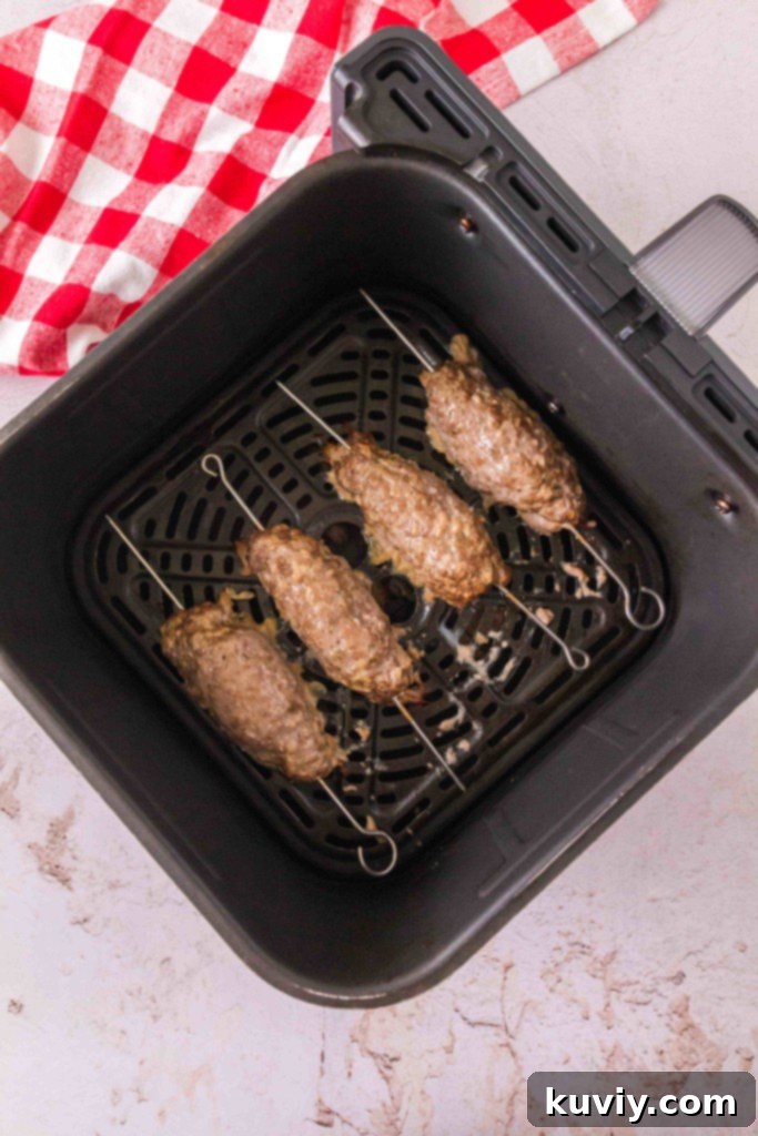 Air Fryer Ground Beef Kebabs cooking in the air fryer basket