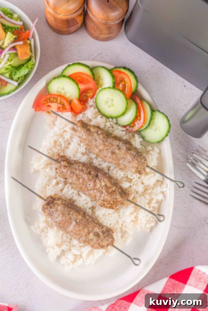 Air Fryer Ground Beef Kebabs on a wooden board with fresh herbs