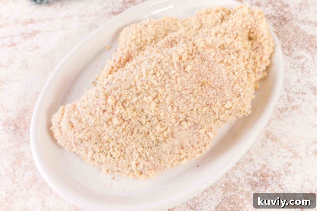 Crispy Air Fryer Chicken Schnitzel 5 Air Fryer Chicken Schnitzel cooking in an air fryer basket