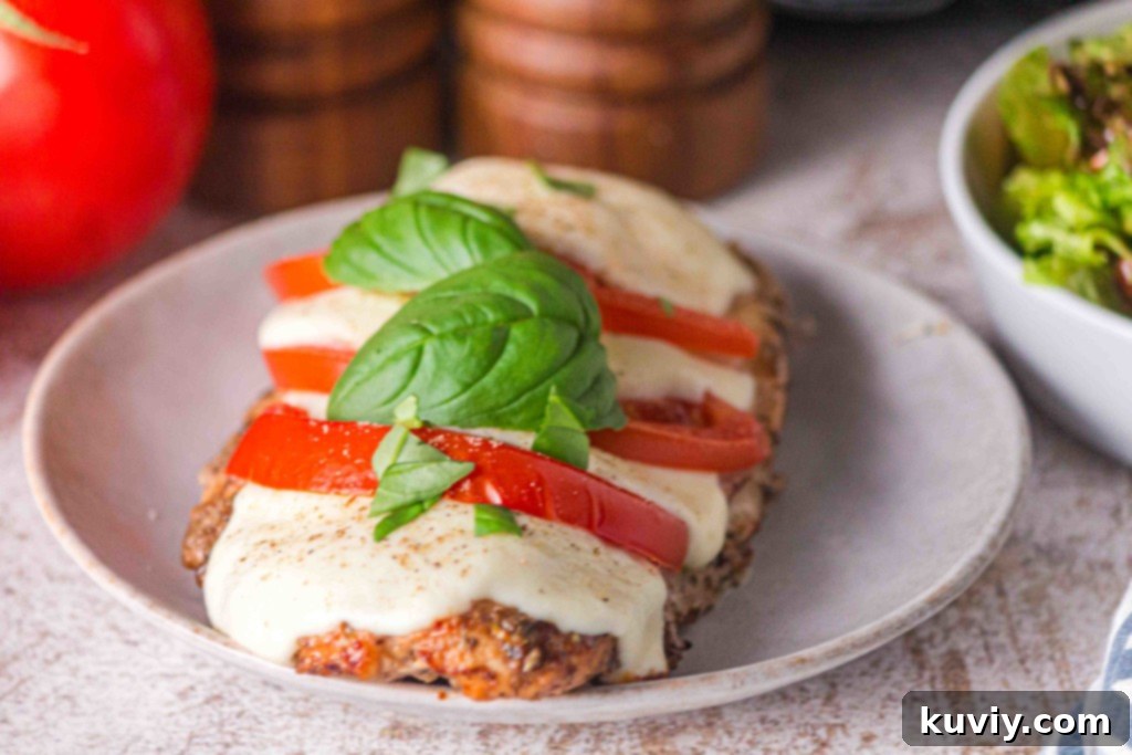 Air fryer basket with cooked Caprese chicken