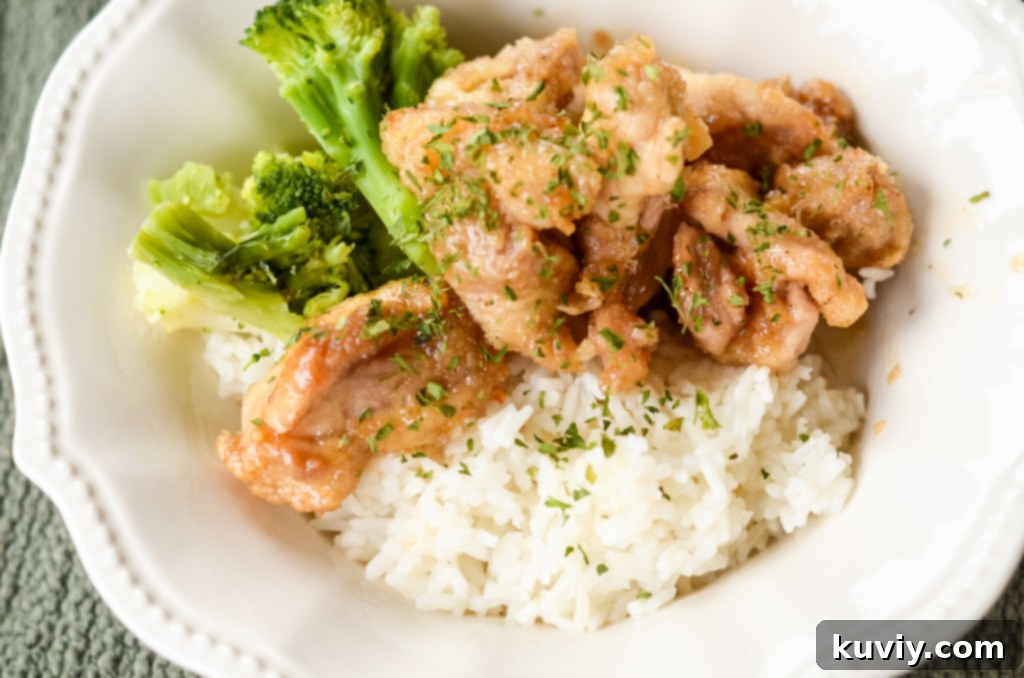 Crispy Hot Honey Air Fryer Chicken Bowls 8 A freshly prepared Air Fryer Hot Honey Chicken Bowl with glazed chicken, rice, and broccoli, garnished with sesame seeds, ready to be enjoyed.
