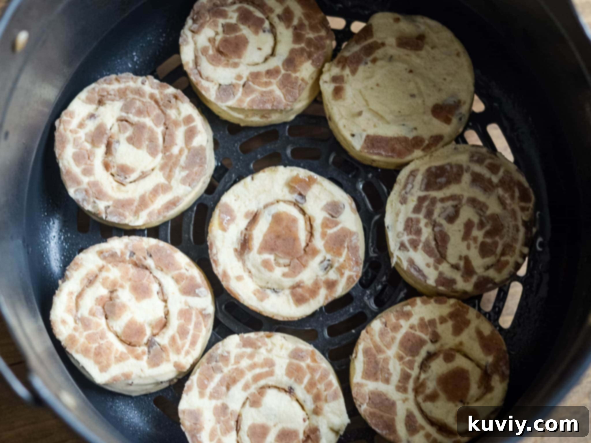close-up of air fryer cinnamon rolls with icing drizzle