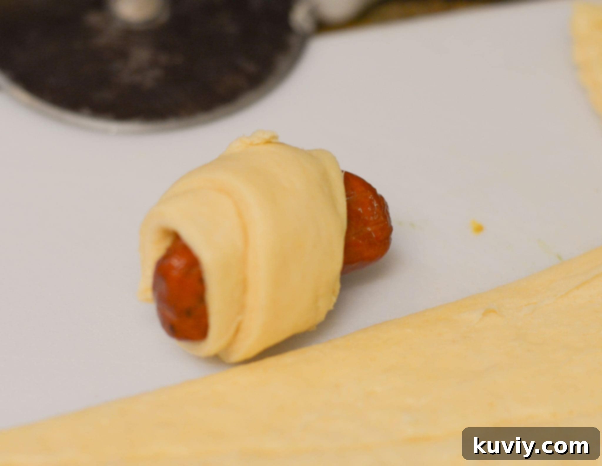 Crispy Air Fryer Pigs in a Blanket 3 Ingredients laid out for Air Fryer Pigs in a Blanket: crescent rolls, cocktail sausages, and olive oil spray.