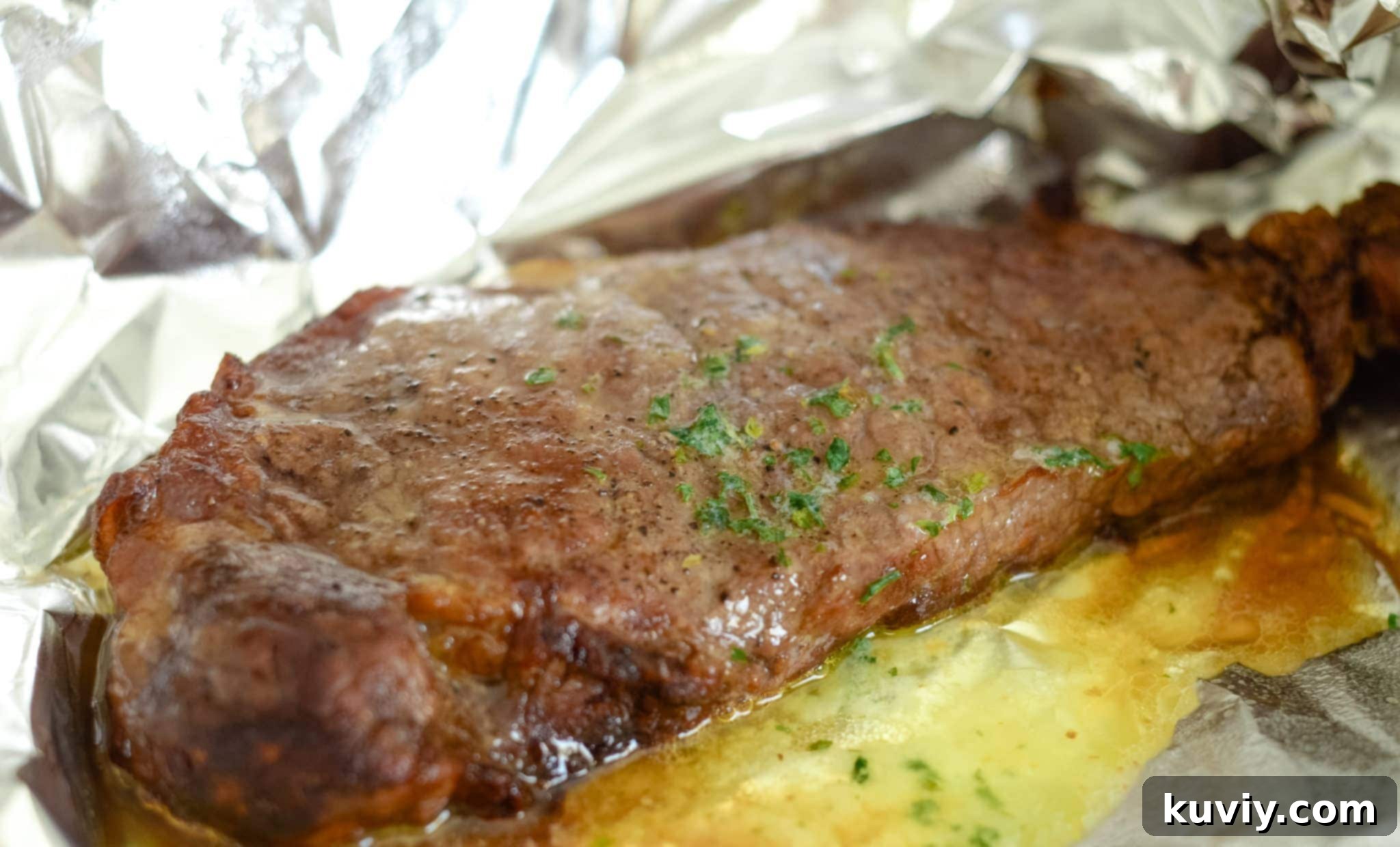 Air Fryer Garlic Butter Steaks being tented with foil for resting