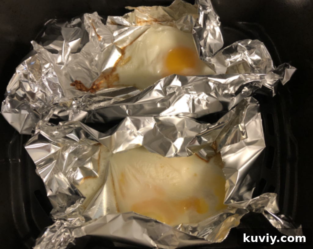 Air Fryer Eggs 5 Four air fried eggs, some garnished with fresh herbs, in colorful ramekins