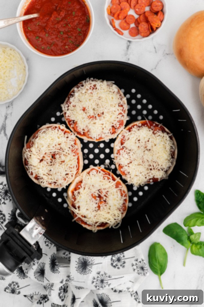 Selection of ingredients for Air Fryer Pizza Bagels: bagels, sauce, cheese, and various toppings
