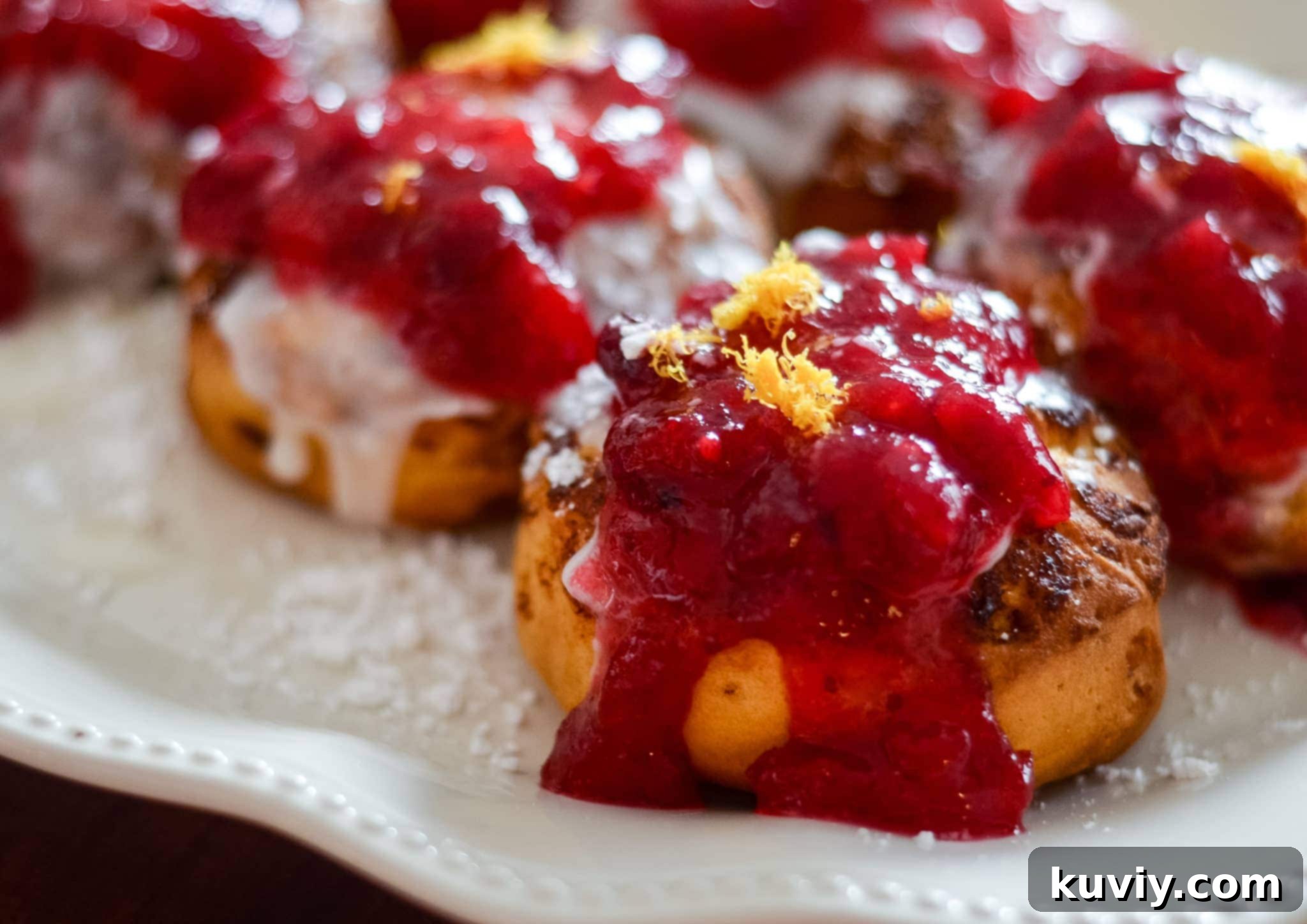 Air Fryer Cranberry Cinnamon Swirls with Zesty Glaze 4 Air Fryer Cranberry Glazed Cinnamon Rolls with orange zest and powdered sugar.