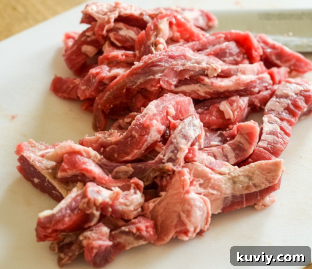 Thinly sliced flank steak seasoned and ready for air frying to make fajitas.