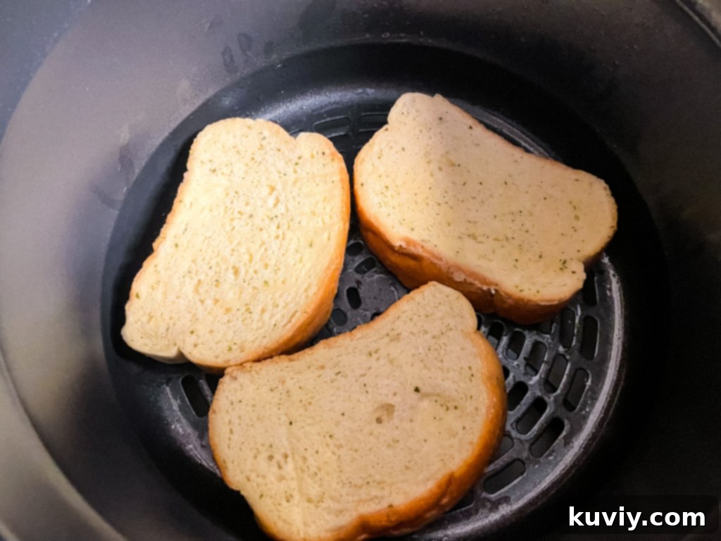 Frozen Texas Toast slices perfectly arranged in an air fryer basket for optimal cooking.