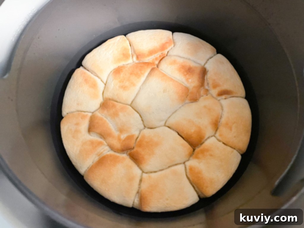 Effortless Air Fryer Dinner Rolls 4 Frozen dinner rolls removed from pan and placed in air fryer basket.