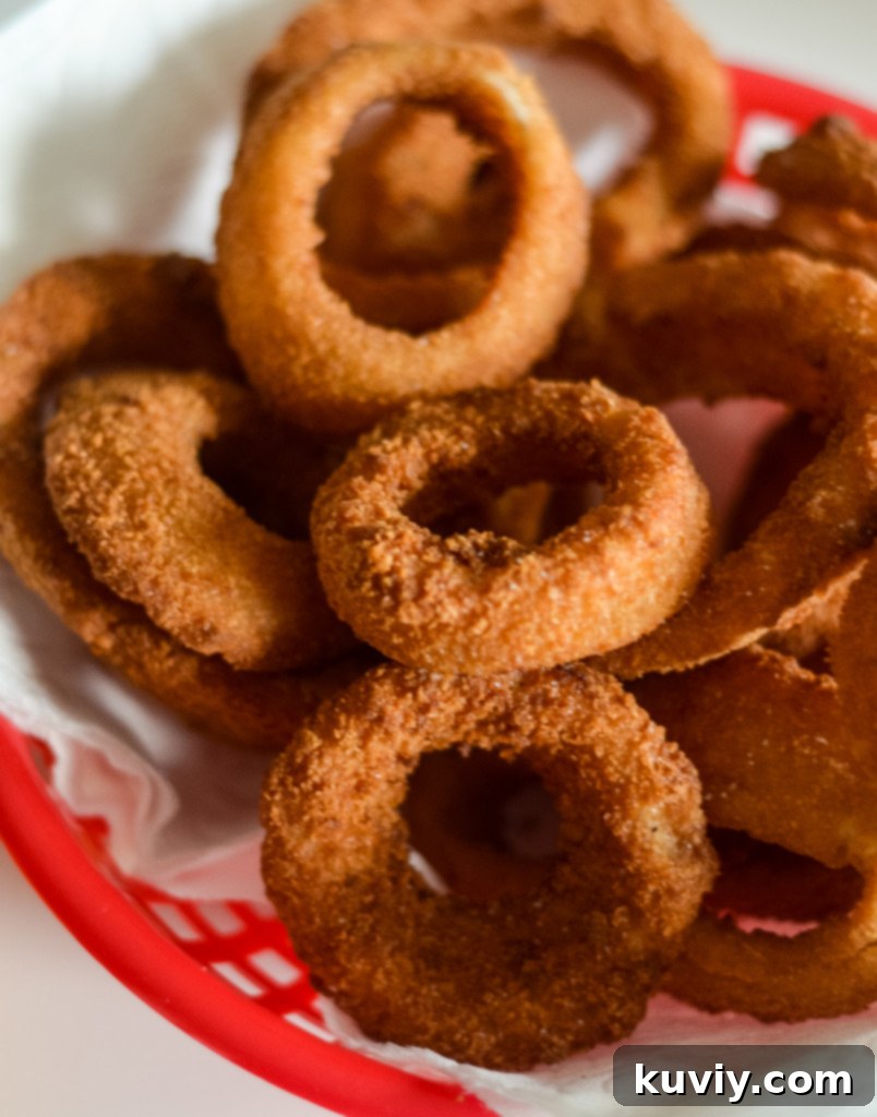 Air fryer basket filled with frozen onion rings in a single layer