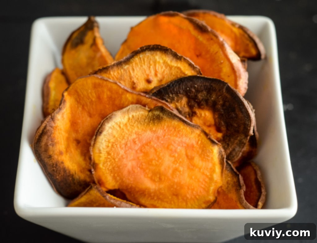 Crispy golden sweet potato chips piled high in a bowl, ready for snacking, made fresh in an air fryer.
