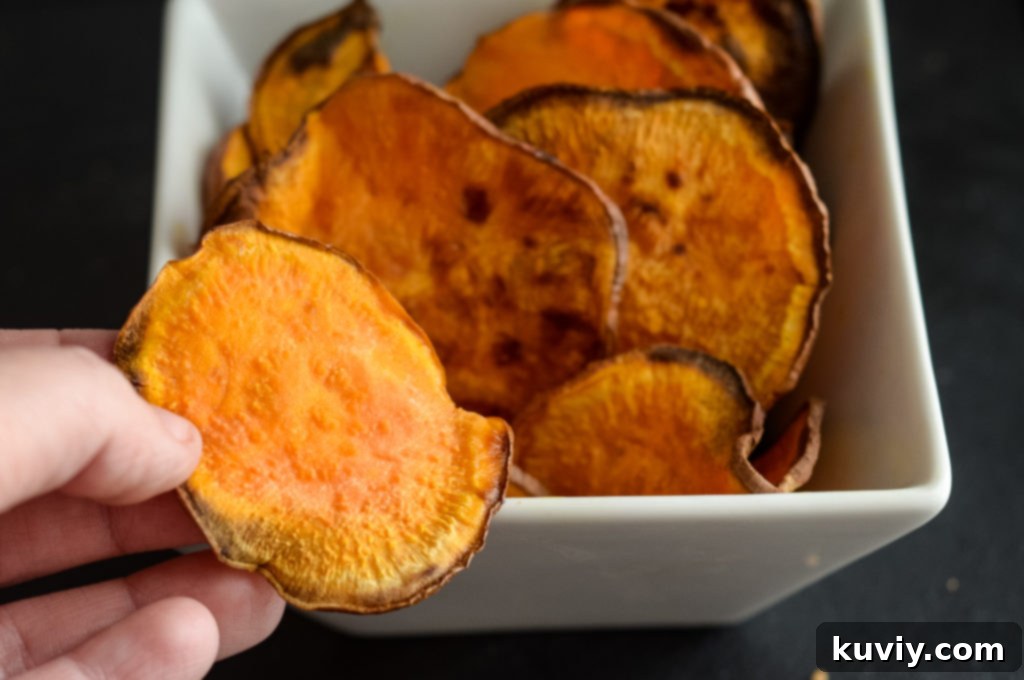 A close-up of thinly sliced sweet potato rounds ready to be seasoned and air-fried for crispy chips.