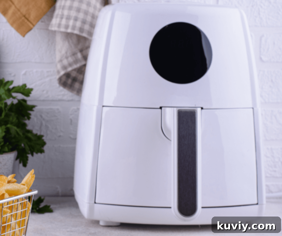 Person cleaning air fryer basket with sponge