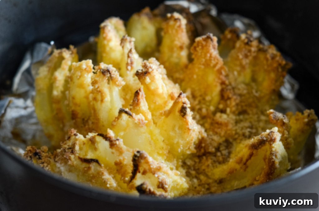 Blooming onion soaking in buttermilk in a glass bowl.
