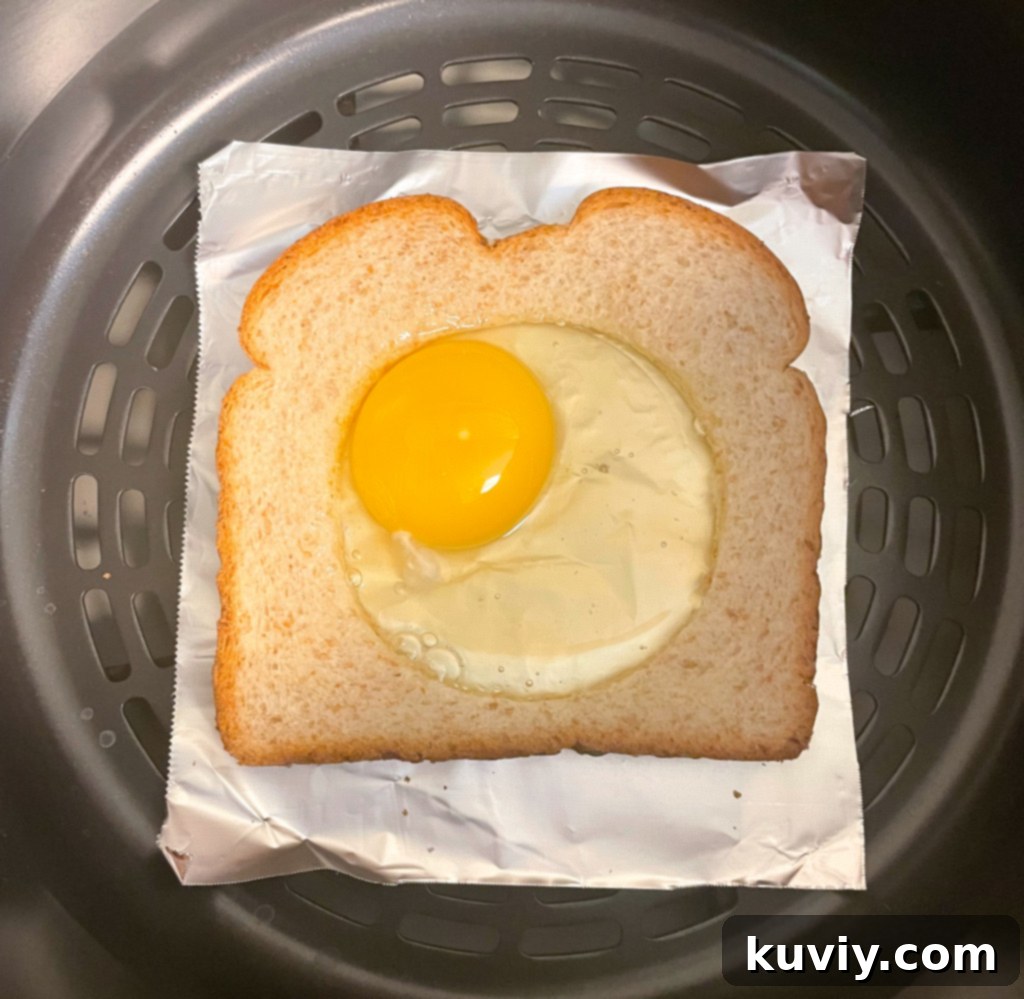 Air Fryer Eggs in a Basket cooking in a Ninja Foodi air fryer.