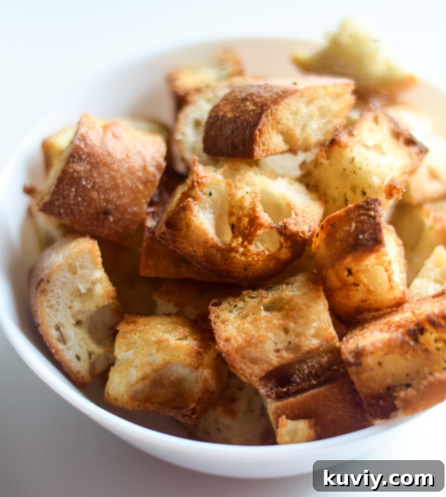 Freshly air fried croutons in an air fryer basket, ready to be transferred