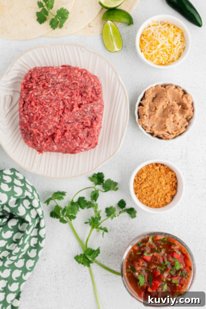 Ingredients laid out for air fryer beef chimichangas, including ground beef, tortillas, and cheese
