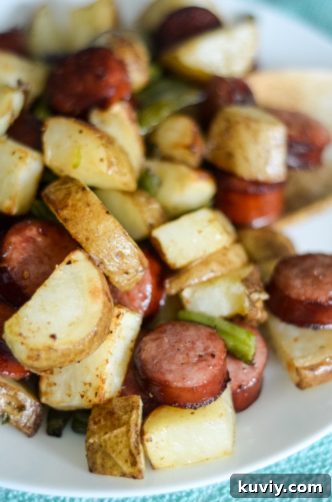 Air fryer kielbasa with vegetables cooking in a Ninja Foodi with the air crisp lid