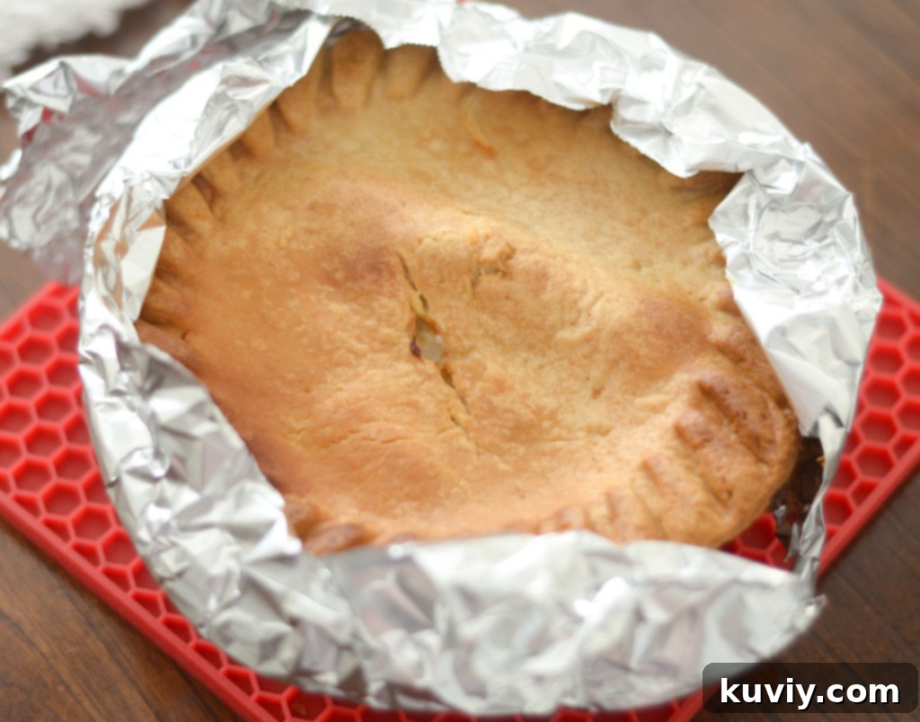Perfect Air Fryer Frozen Pot Pie 6 Applying aluminum foil to the edges of a frozen pot pie