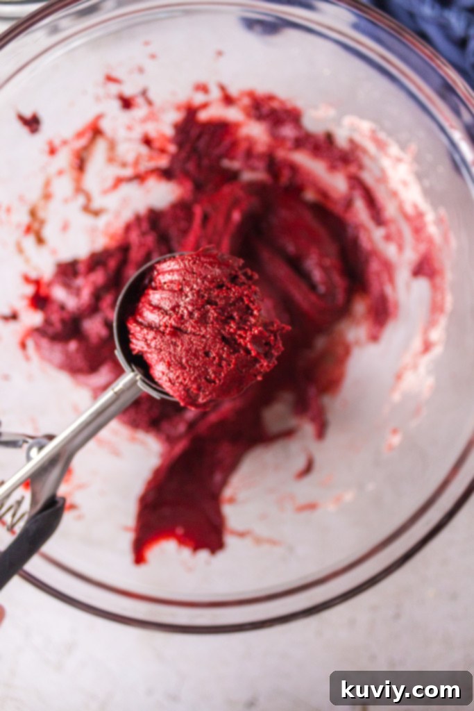 ingredients laid out for air fryer red velvet crinkle cookies including a box of cake mix, eggs, vegetable oil, vanilla extract, and powdered sugar
