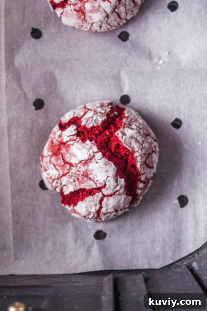 air fryer red velvet crinkle cookie dough balls on pre-cut parchment paper in an air fryer basket