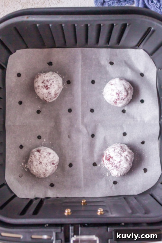 red velvet cookie dough being thoroughly mixed in a bowl with a Danish dough whisk to achieve the right consistency