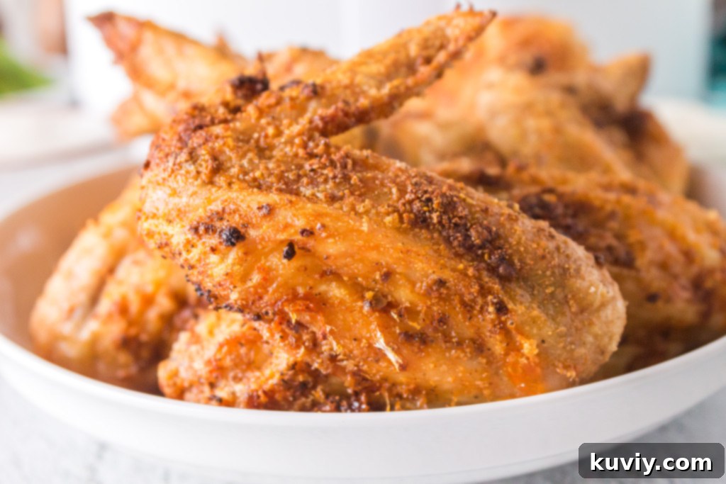 Air Fryer Crispy Chicken Wings being sprayed with oil