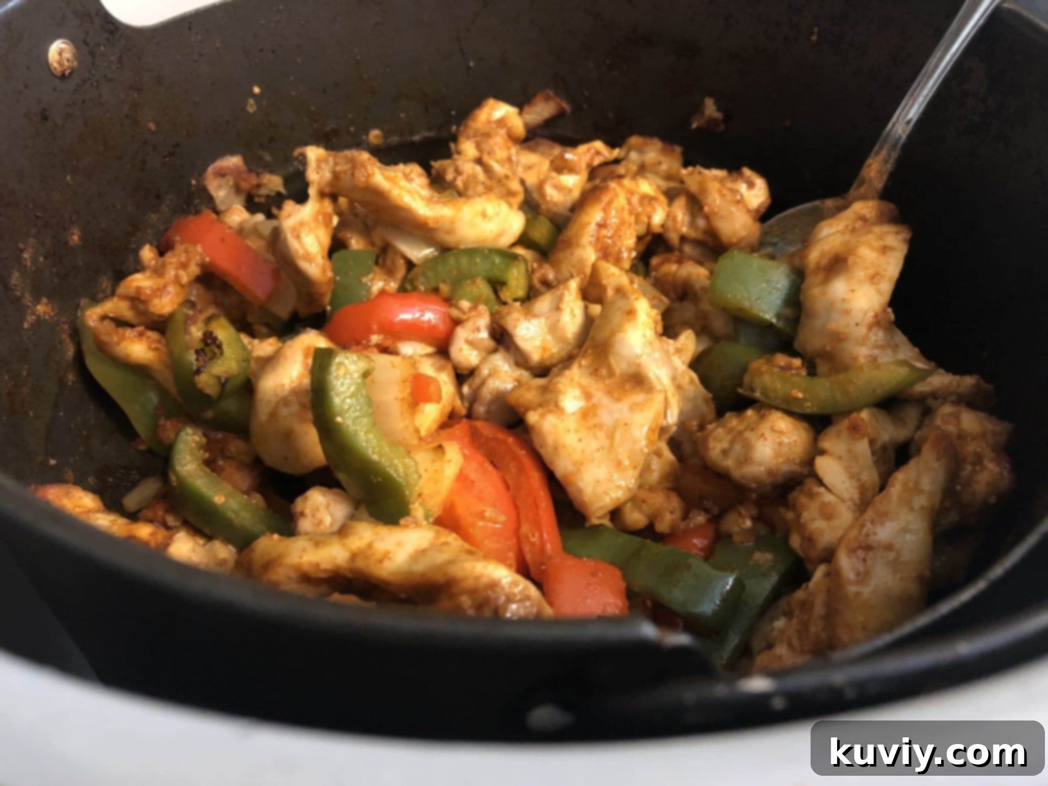 Ninja Foodi multi-cooker with the crisper basket containing chicken fajitas mixture.