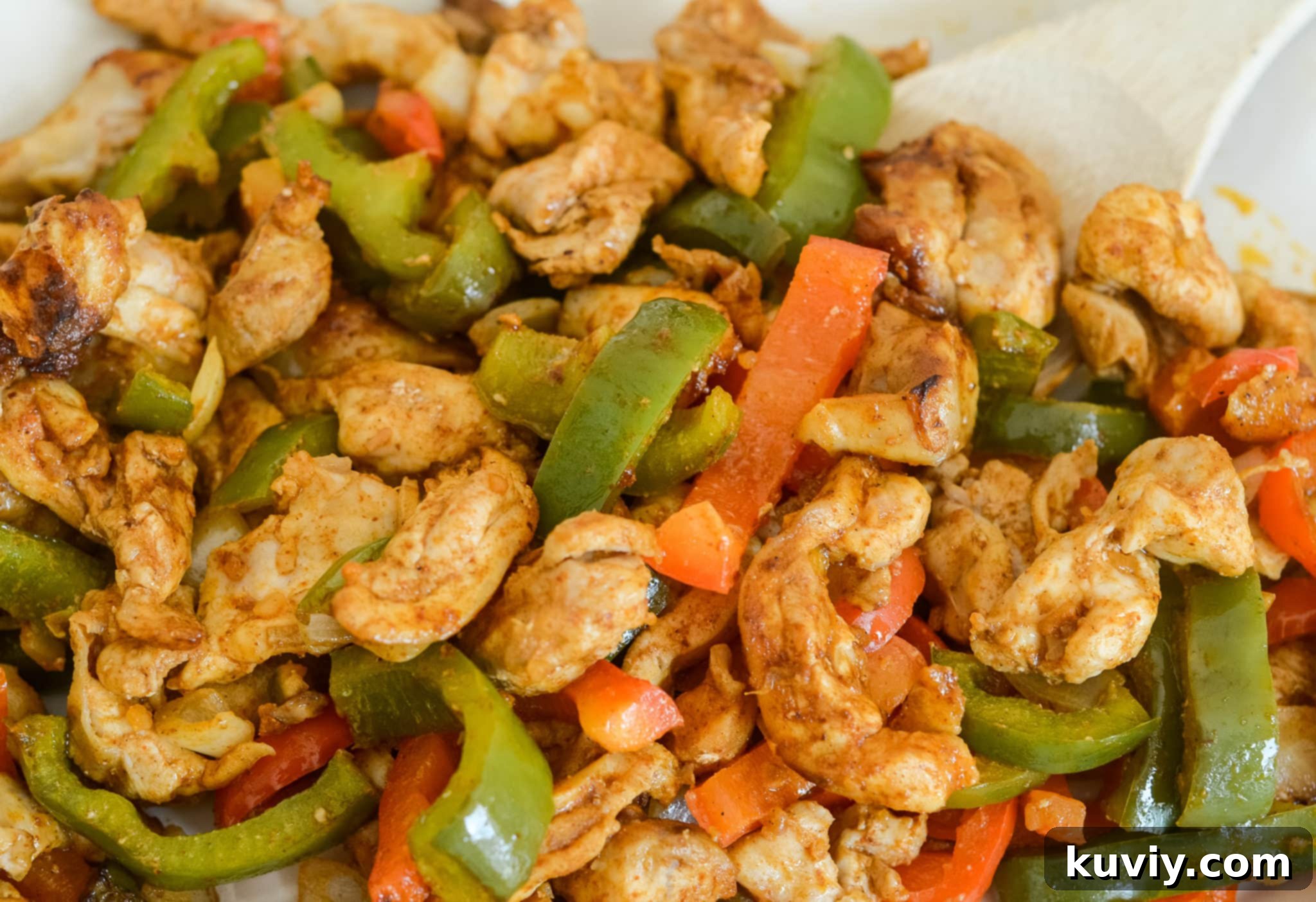 Prepared chicken fajita ingredients, including sliced chicken, bell peppers, and onions, in a freezer-safe bag.
