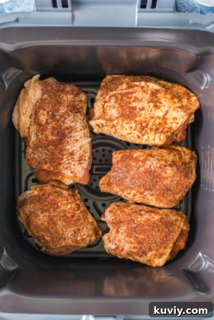 Air Fryer BBQ Chicken Thighs cooking in the basket