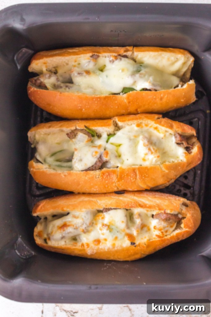 Perfectly cooked Air Fryer Philly Cheesesteak with melted cheese and tender steak and vegetables on a hoagie roll.