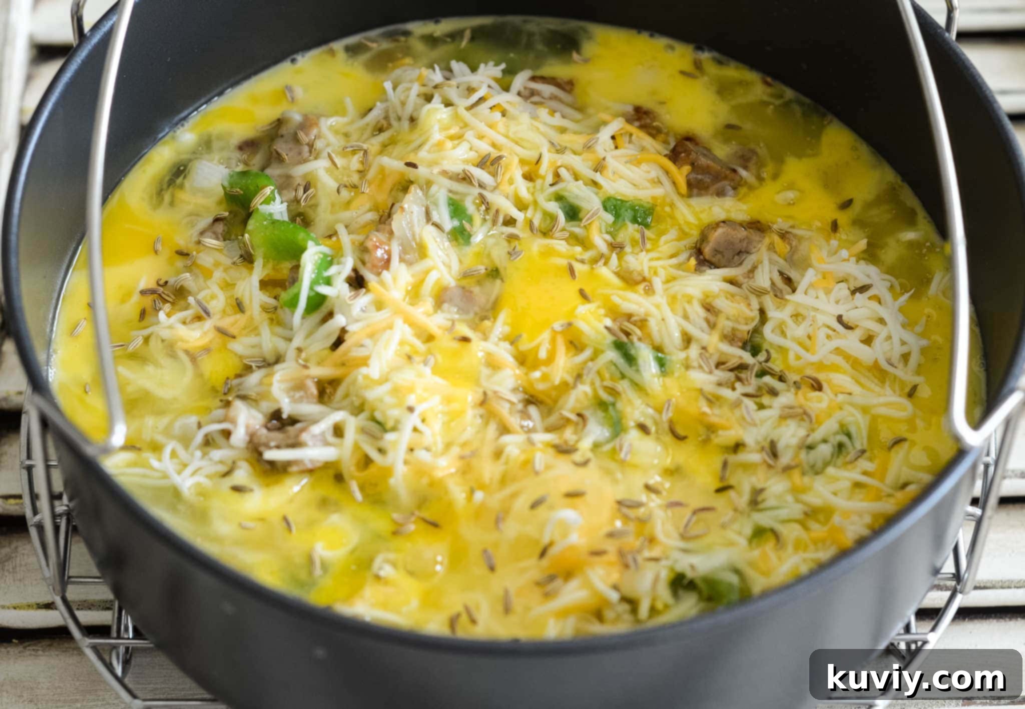 Hands preparing the Air Fryer Low-Carb Breakfast Casserole ingredients in a pan