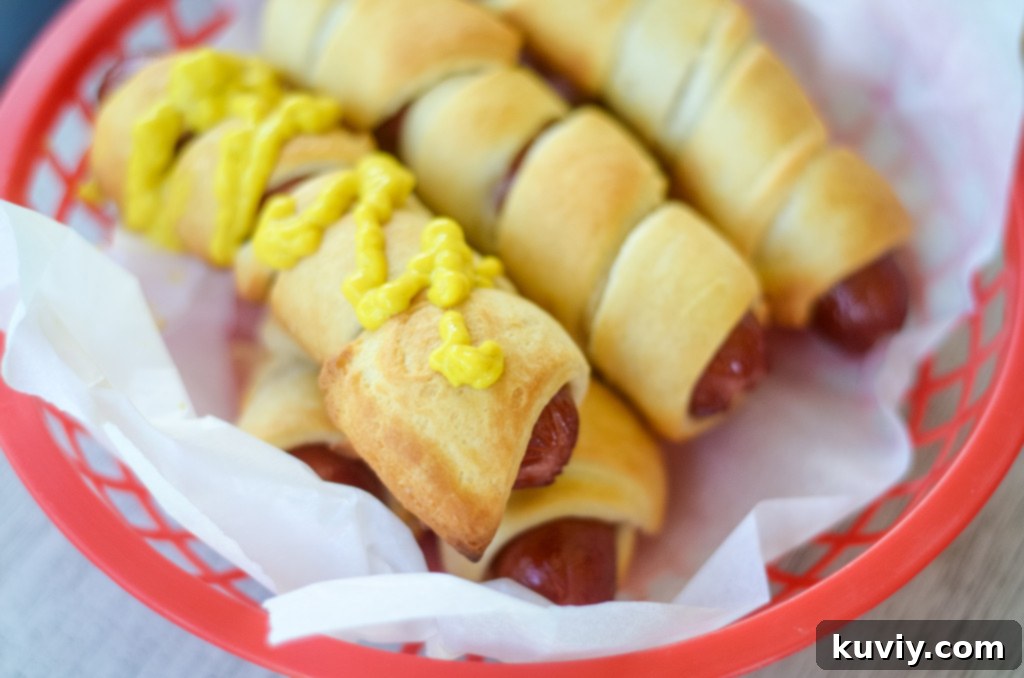 Crispy Air Fryer Crescent Hot Dogs 6 Air fryer basket lined with parchment paper, holding crescent hot dogs