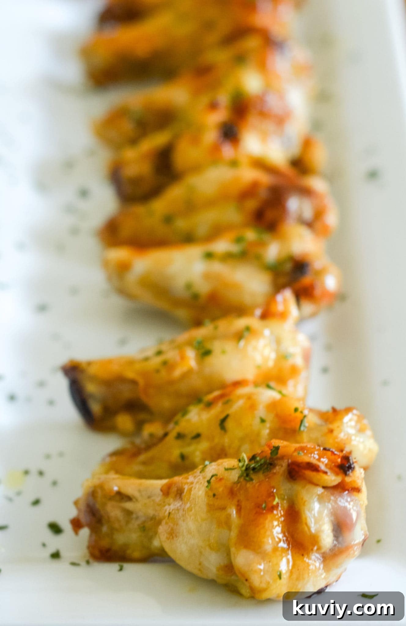 Perfectly glazed Air Fryer Honey Garlic Chicken Wings stacked on a plate, ready to serve.