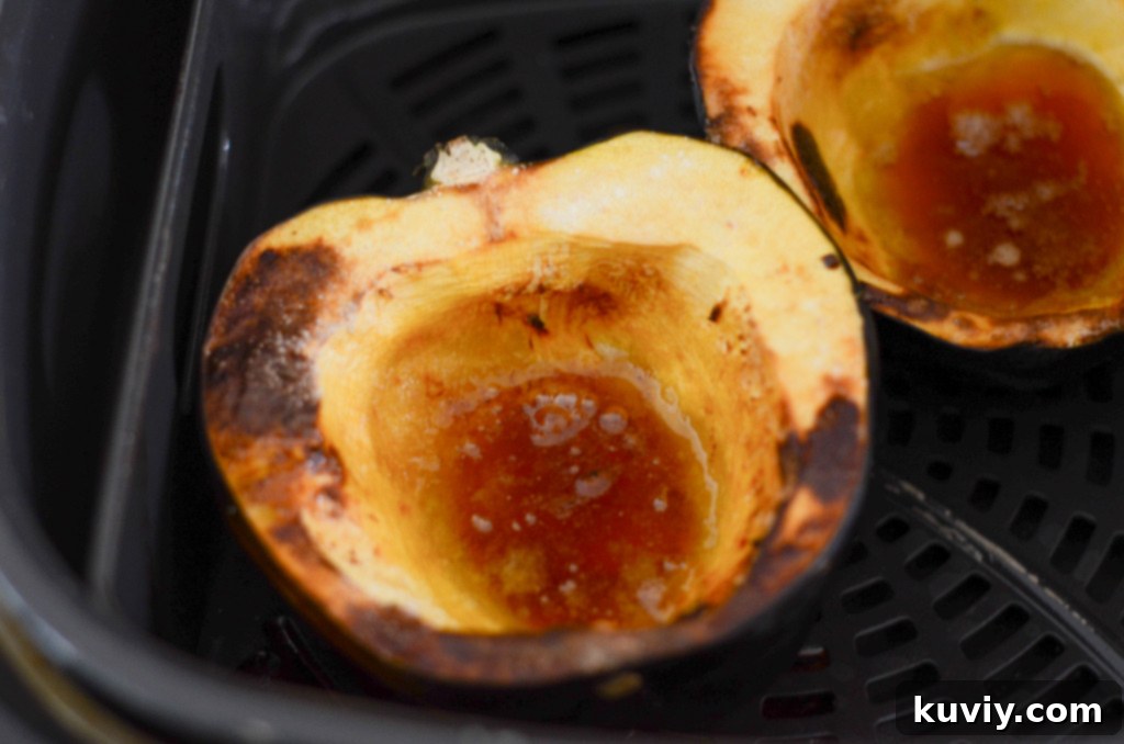 Close-up of golden brown air fryer acorn squash in a basket
