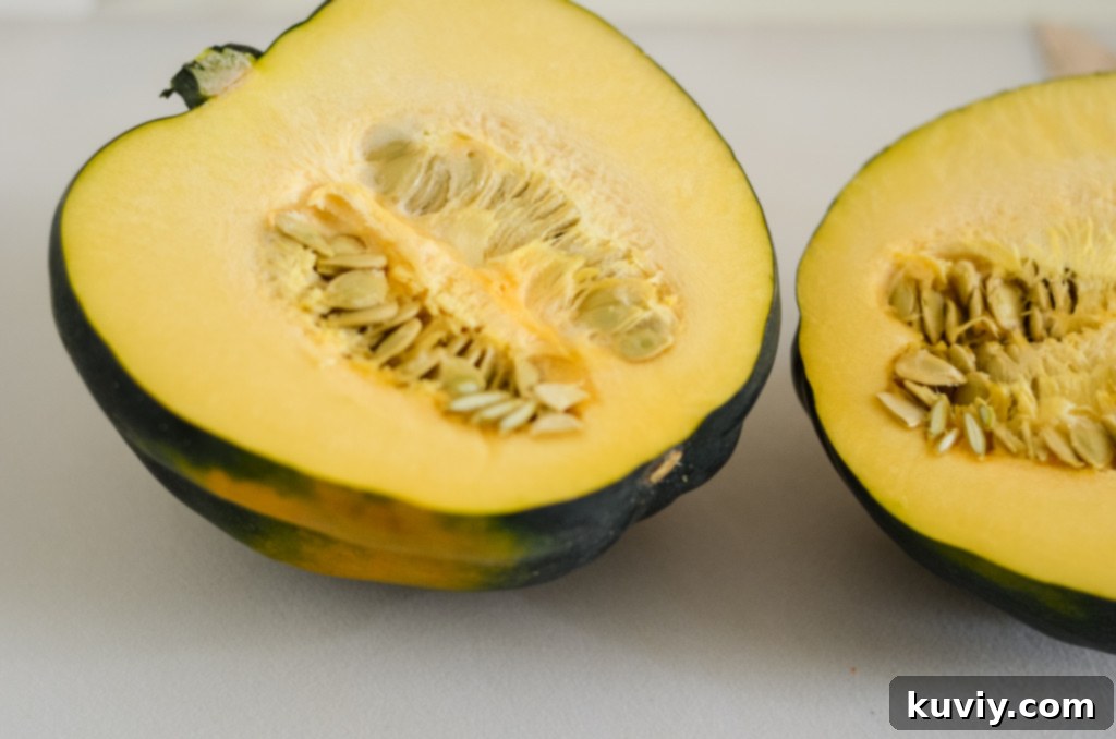 Chef cutting an acorn squash in half on a wooden board