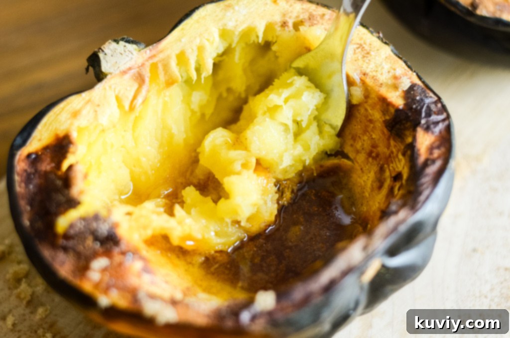 Air fryer acorn squash with spoon, showing soft interior
